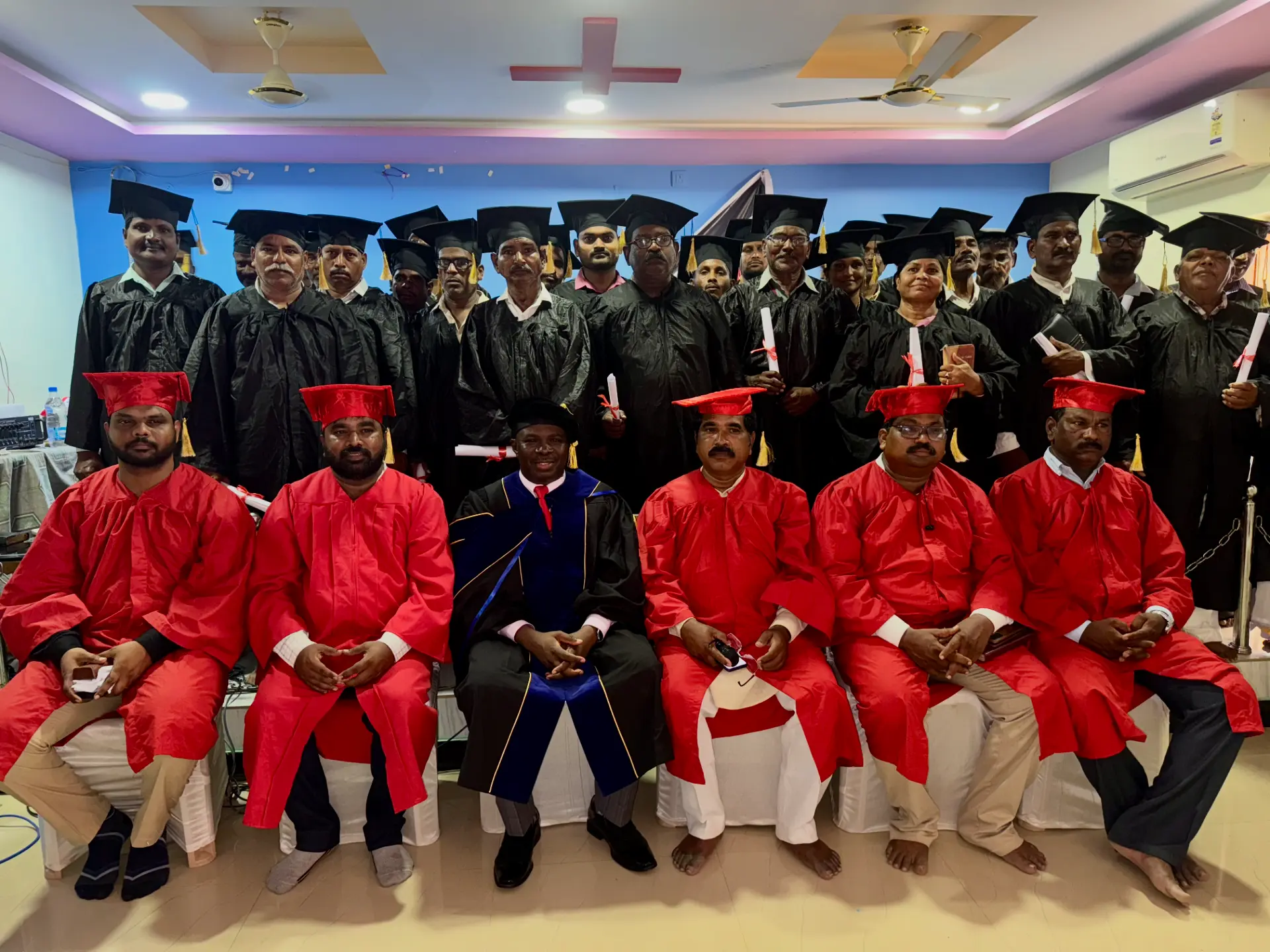 Glovim Bible College India graduating class of 2025 in caps and gowns holding their diplomas